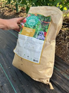 A brown bag of garden fertilizer that has a green and white label.