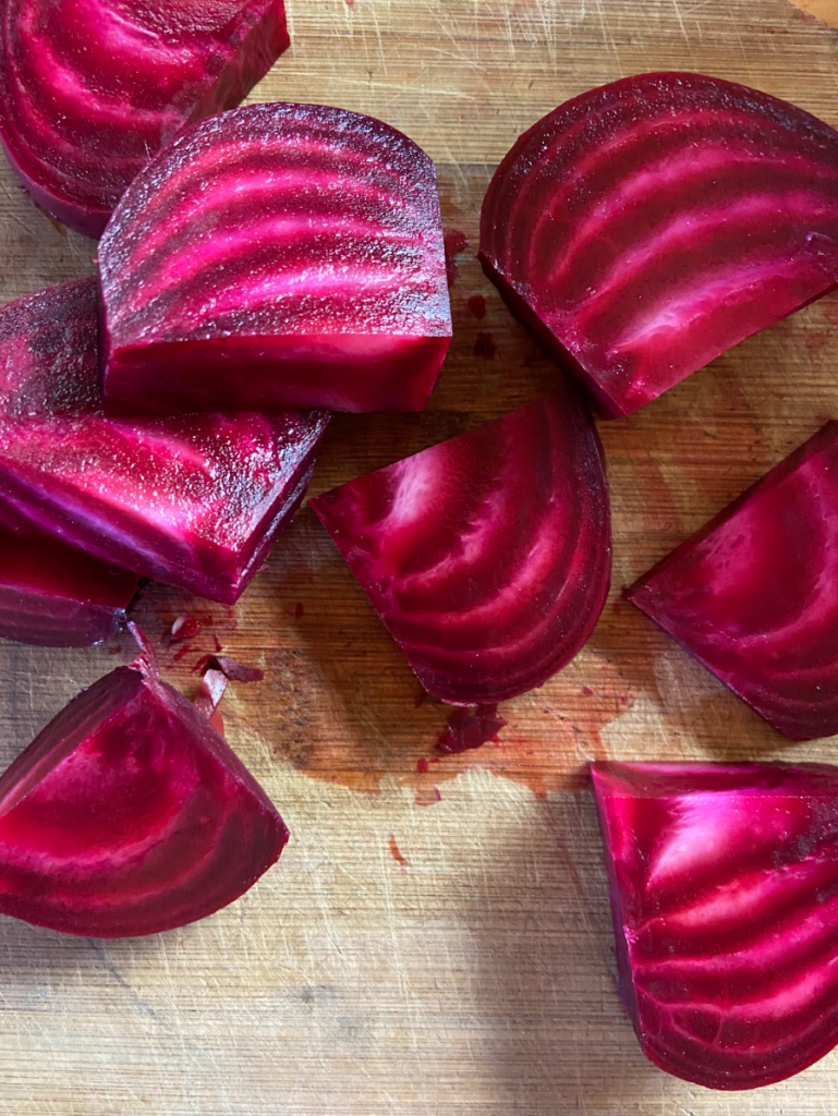 Garden fresh beets cut in slices that have lines of variegated color.