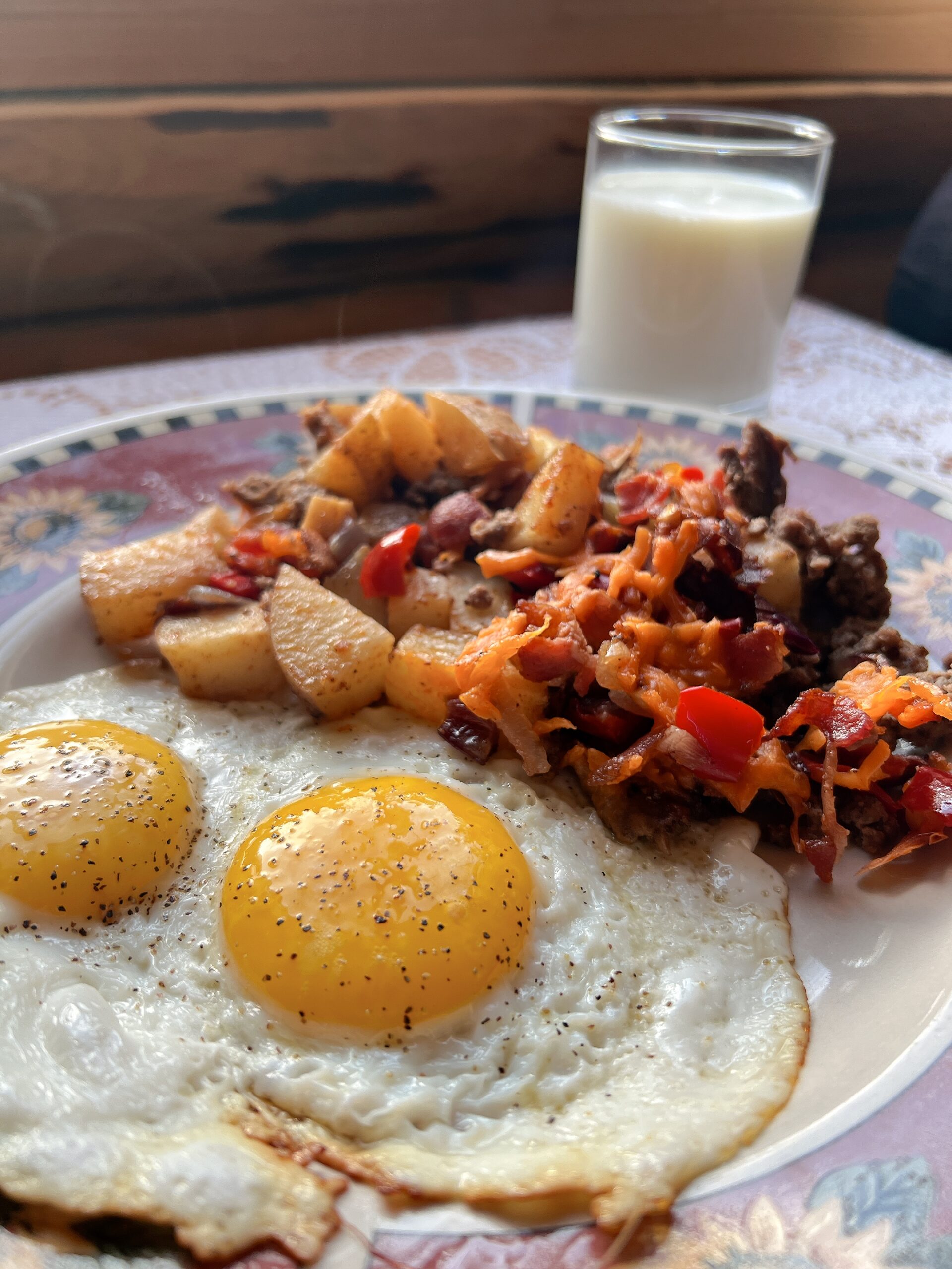 Baked Crispy Hashbrown Casserole on a plate with two sunny side up eggs.