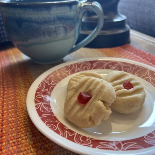 A white plate with 3 shortbread cookies on a wooden island.