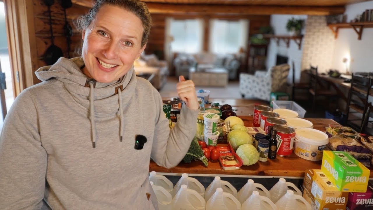 Chelsea standing in front of a table with a variety of fresh groceries.