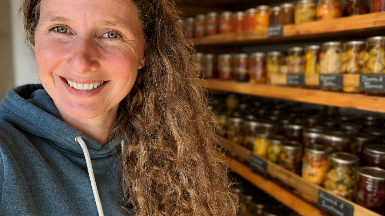 A close up of Chelsea in front of her canning pantry shelves full of canned goods.