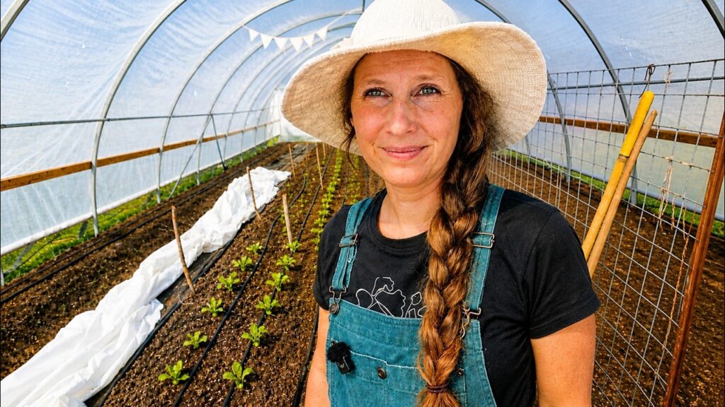 Chelsea in the high tunnel in front of growing seedlings.