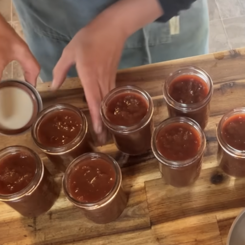 7 open half pint jars of prepared rhubarb bbq sauce.