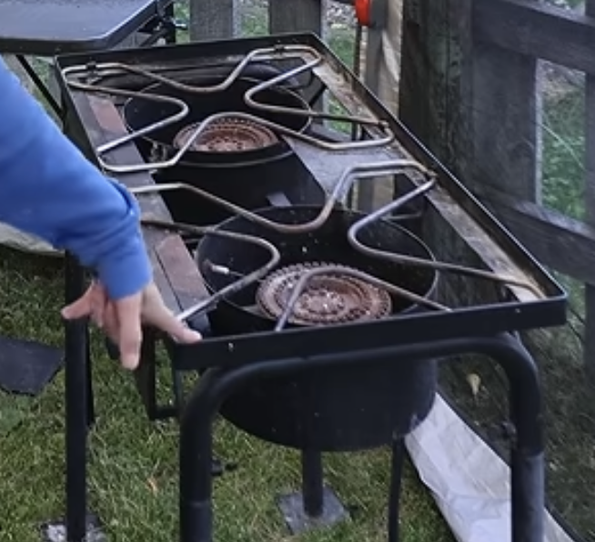 Chelsea pointing to a Coleman propane double burner.